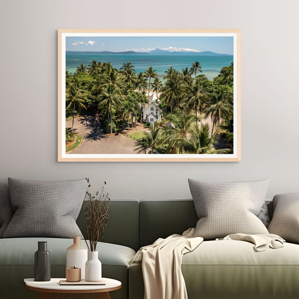 Rolling to the Seaside – Aerial view over St Mary’s, Port Douglas on a perfectly flat day with tropical waters, blue skies, and distant mountains | Framed Paper Print
