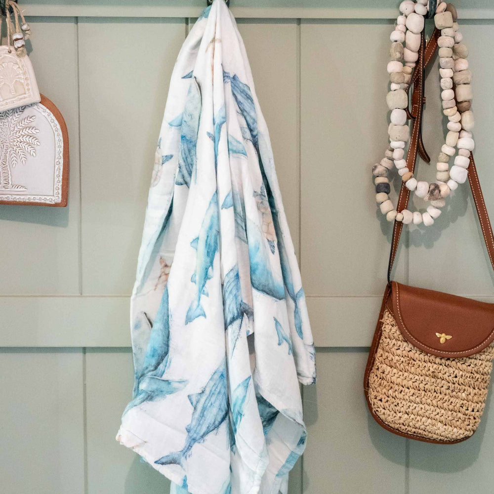 sea life baby swaddle featuring whale, turtle and sharks - hanging on wall