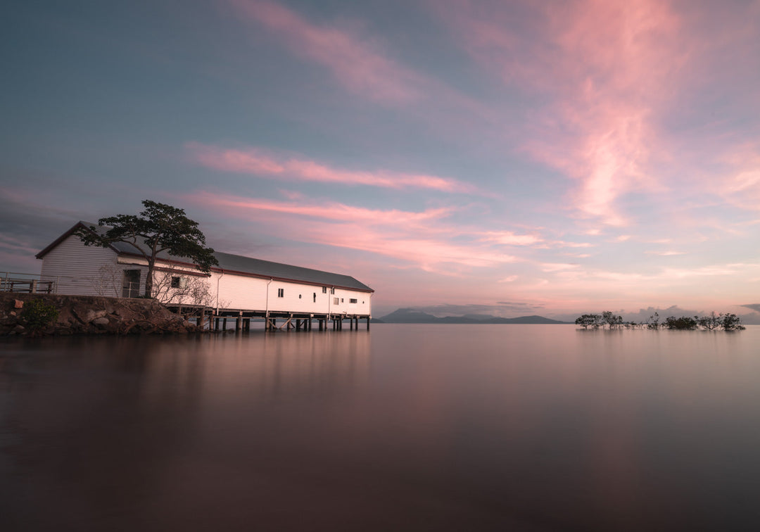Serenity at Sugar – Aerial view of Port Douglas Sugar Wharf at sunrise with magenta-streaked sky and Four Mile Beach in background | Unframed Rolled Print