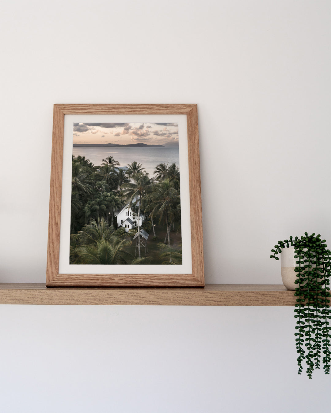 So Easy To Fall In Love – St Mary’s Chapel, Coastal Photography by David Lloyd, framed paper print in oak frame, styled in a timber shelf setting