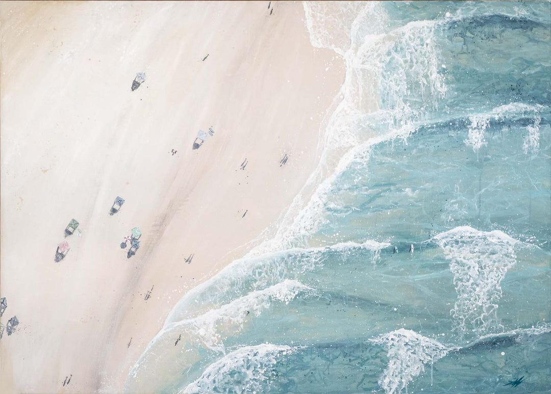 Top-down view of a beach with people and cars, showing the interaction between sand and water.