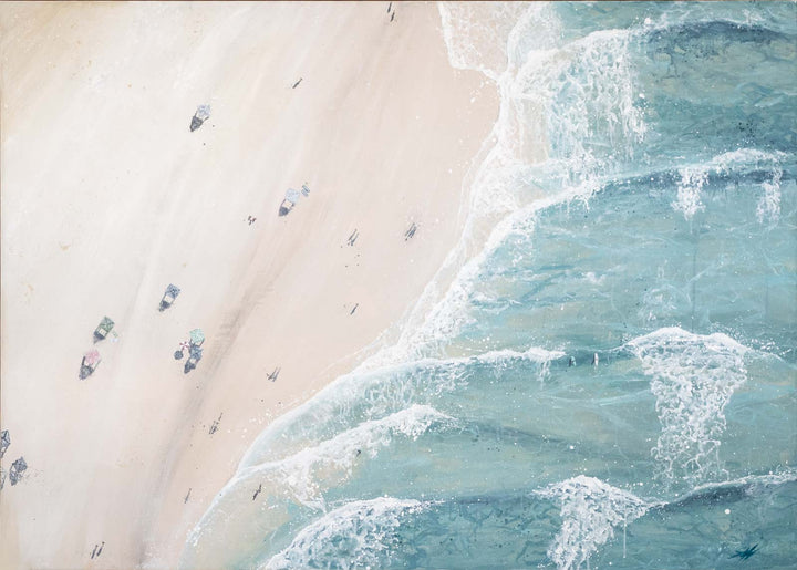 Top-down view of a beach with people and cars, showing the interaction between sand and water.
