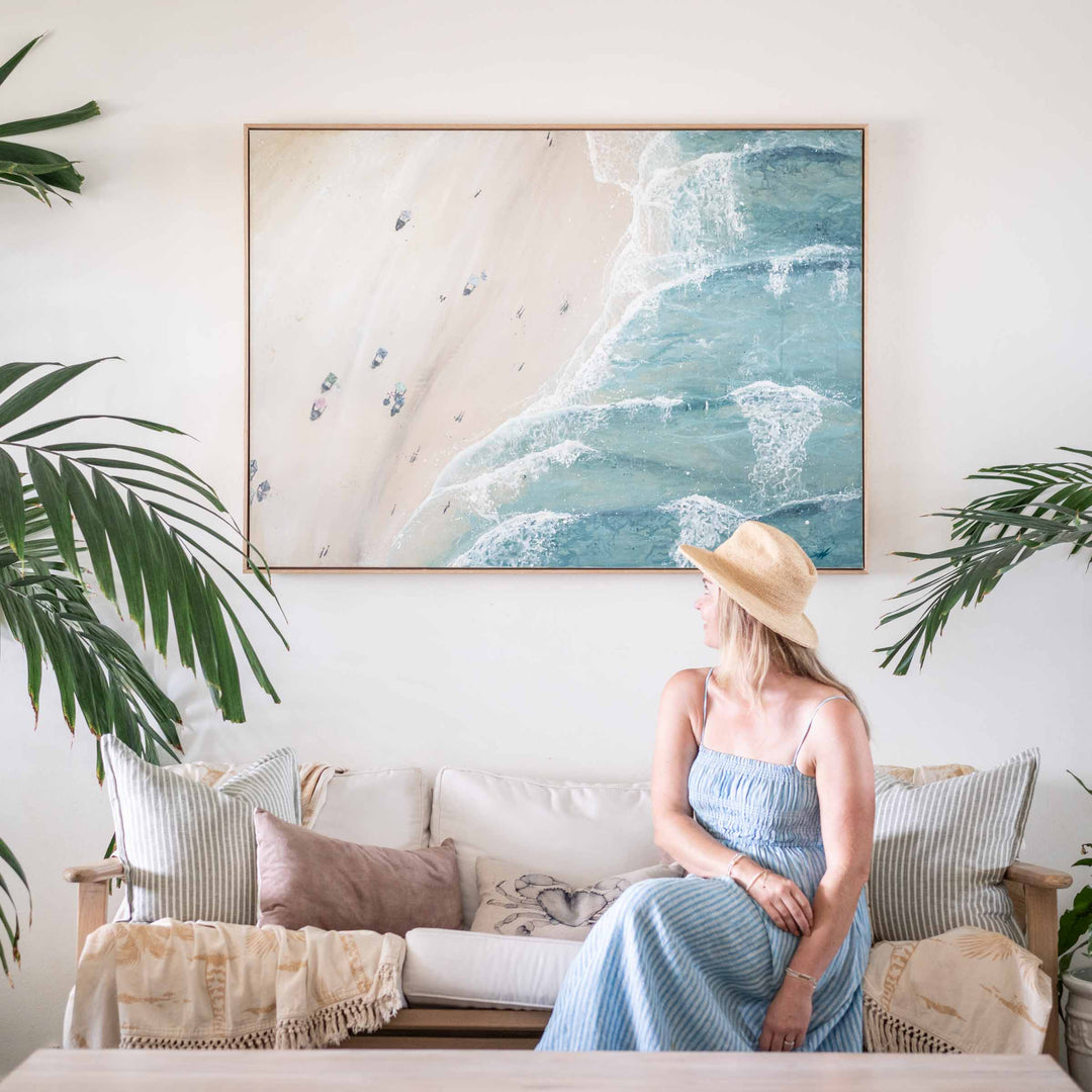 Soaking Up Summer – coastal aerial beach painting with ocean waves and shoreline styled in relaxed interior with figure for scale by Stephanie Elizabeth | Original Artwork