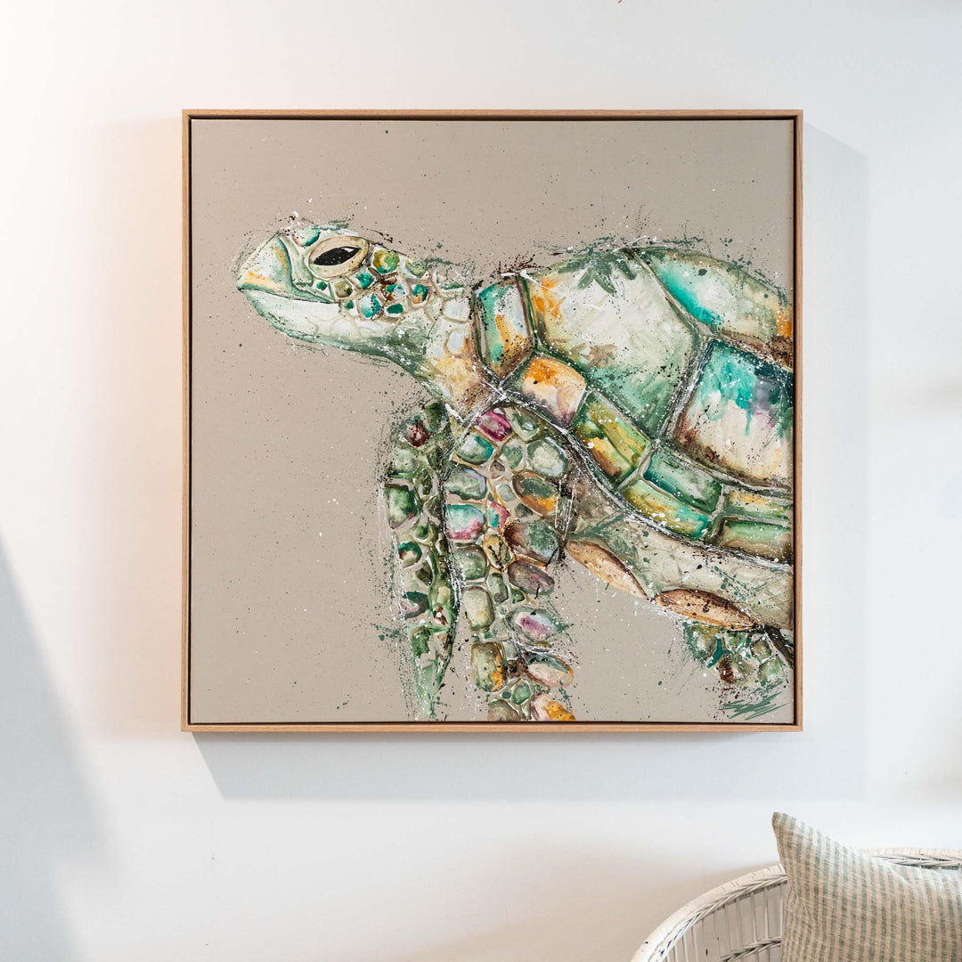 Solstice Serenity acrylic painting framed and hung above a wicker chair in a bright, inviting room.