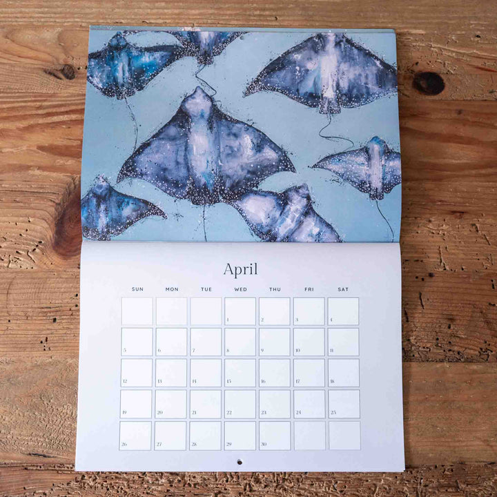 Calendar with blue stingray design on a wooden surface