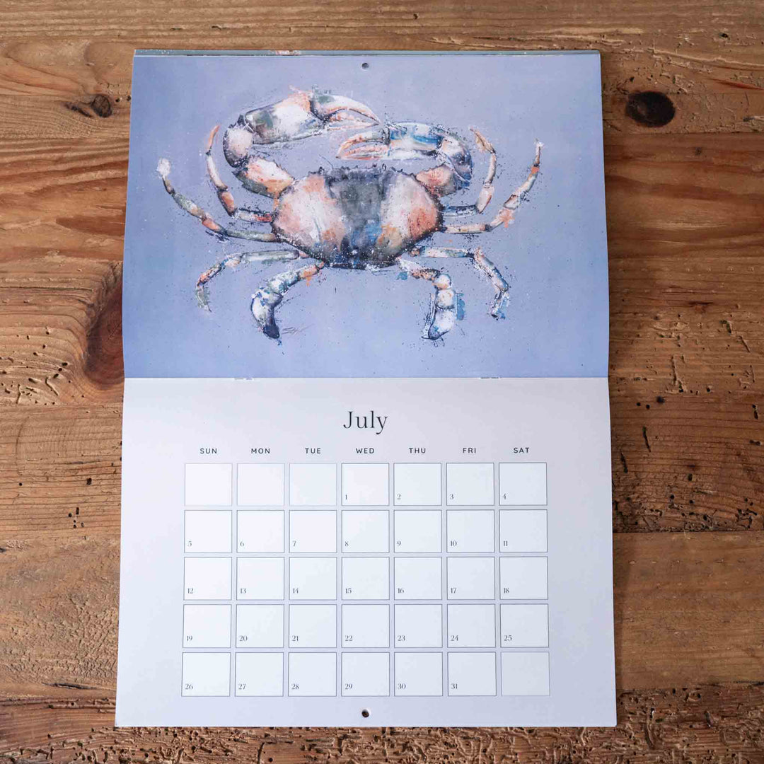 Calendar with a crab illustration on a wooden surface