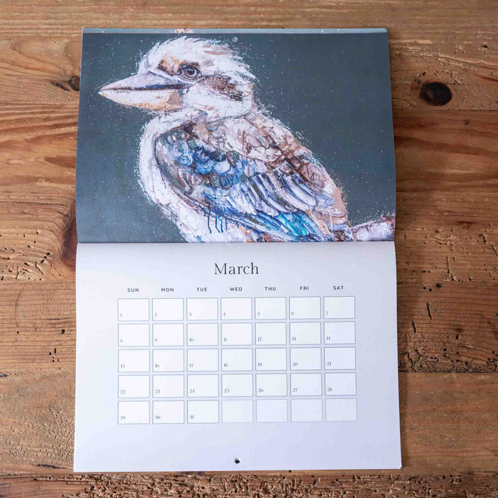 Calendar with a kookaburra illustration on a wooden surface
