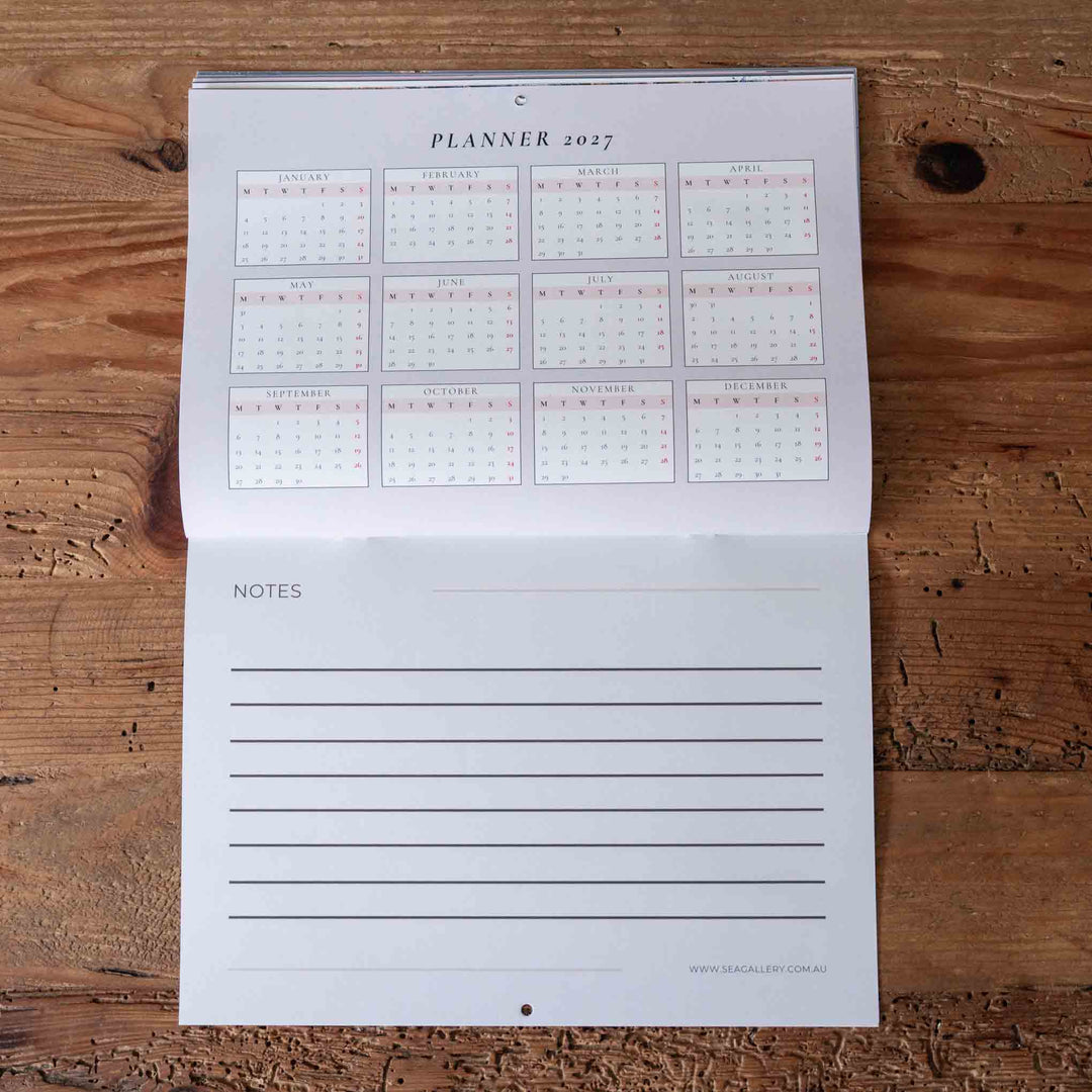 Planner with calendar and notes section on a wooden surface