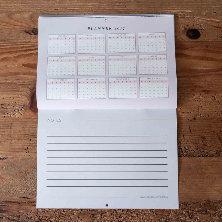 Planner with calendar and notes section on a wooden surface