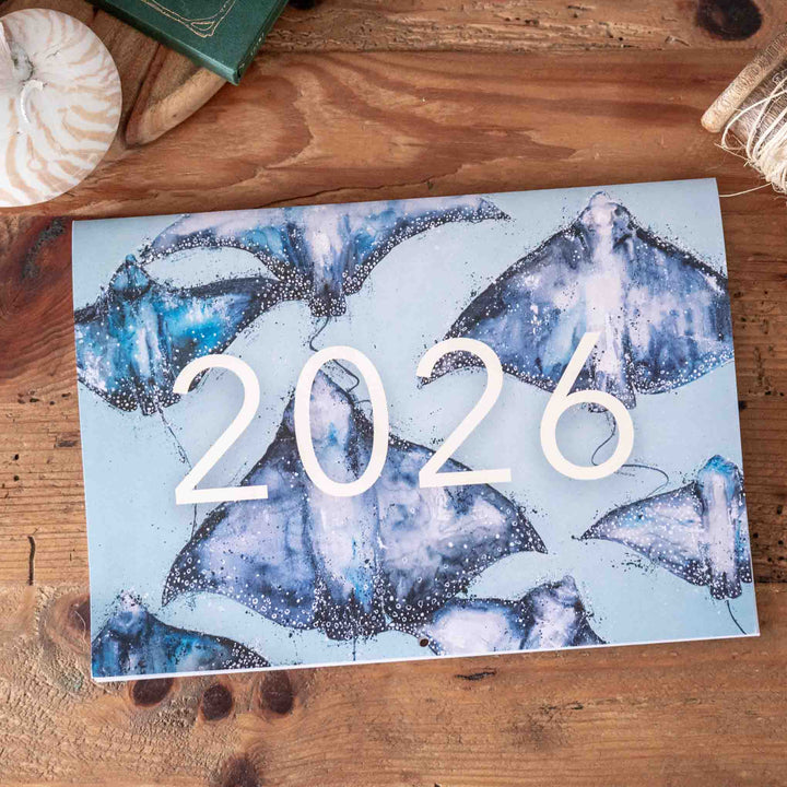 Calendar with blue abstract design and '2026' on a wooden surface