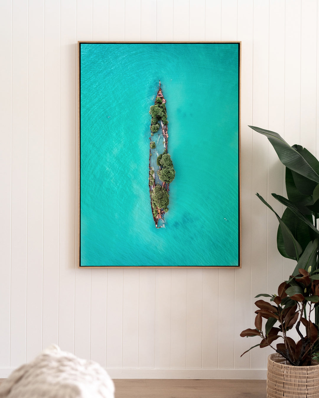 Sunken Solitude – Magnetic Island Shipwreck, Aerial Photography by David Lloyd, framed canvas print in oak float frame, styled in a living room setting
