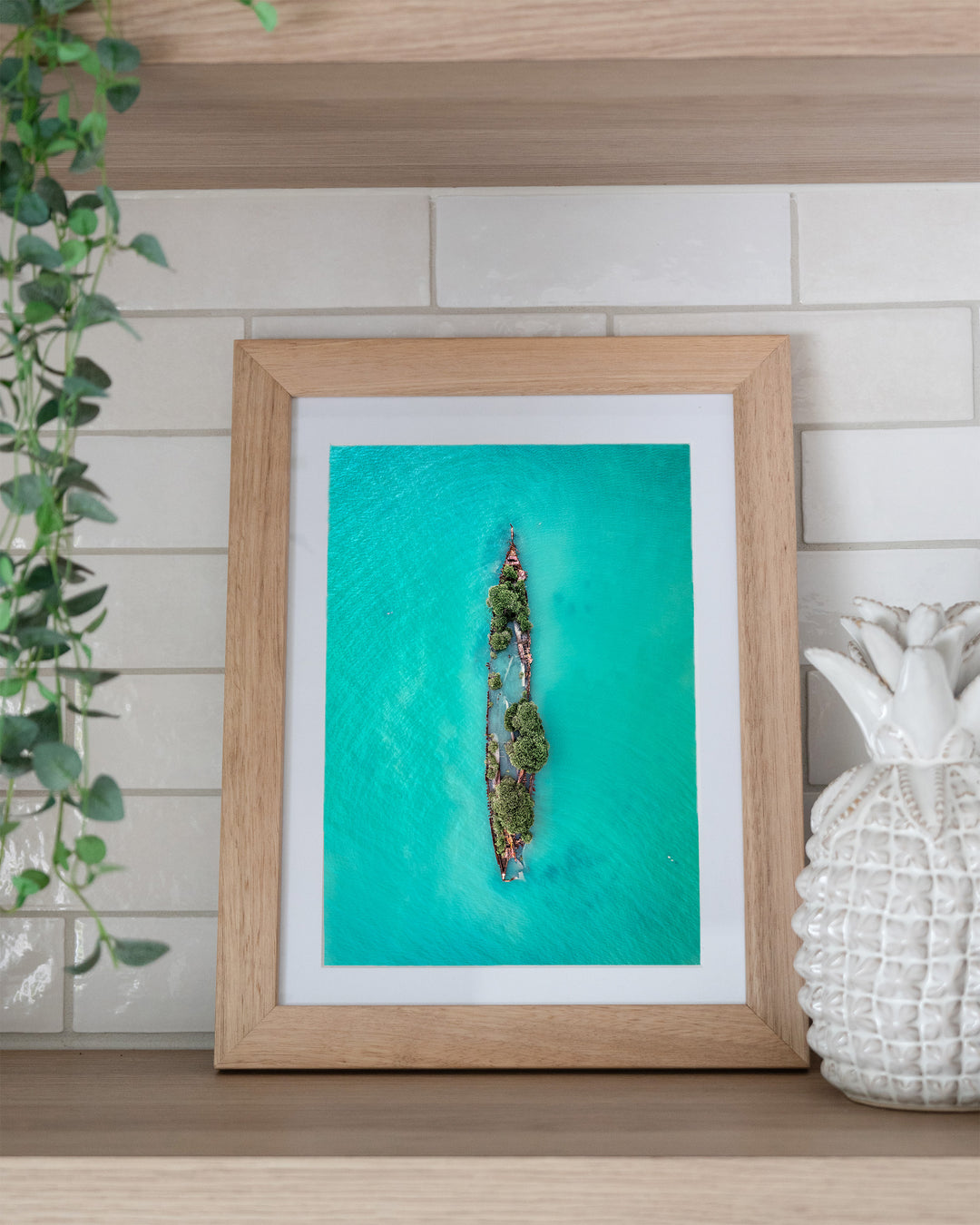 Sunken Solitude – Magnetic Island Shipwreck, Aerial Photography by David Lloyd, framed paper print in oak frame, styled in a kitchen shelf setting