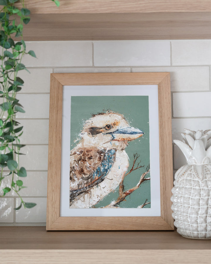 The Early Bird – kookaburra, framed paper print in oak frame, styled on a kitchen shelf