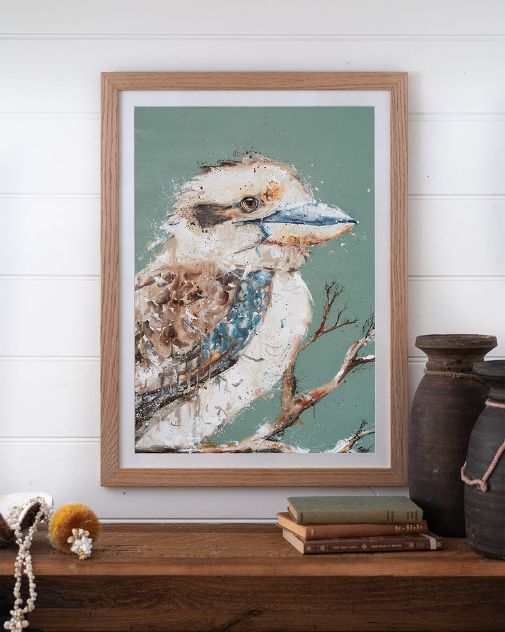 The Early Bird – kookaburra, framed paper print in oak frame, styled on a timber shelf