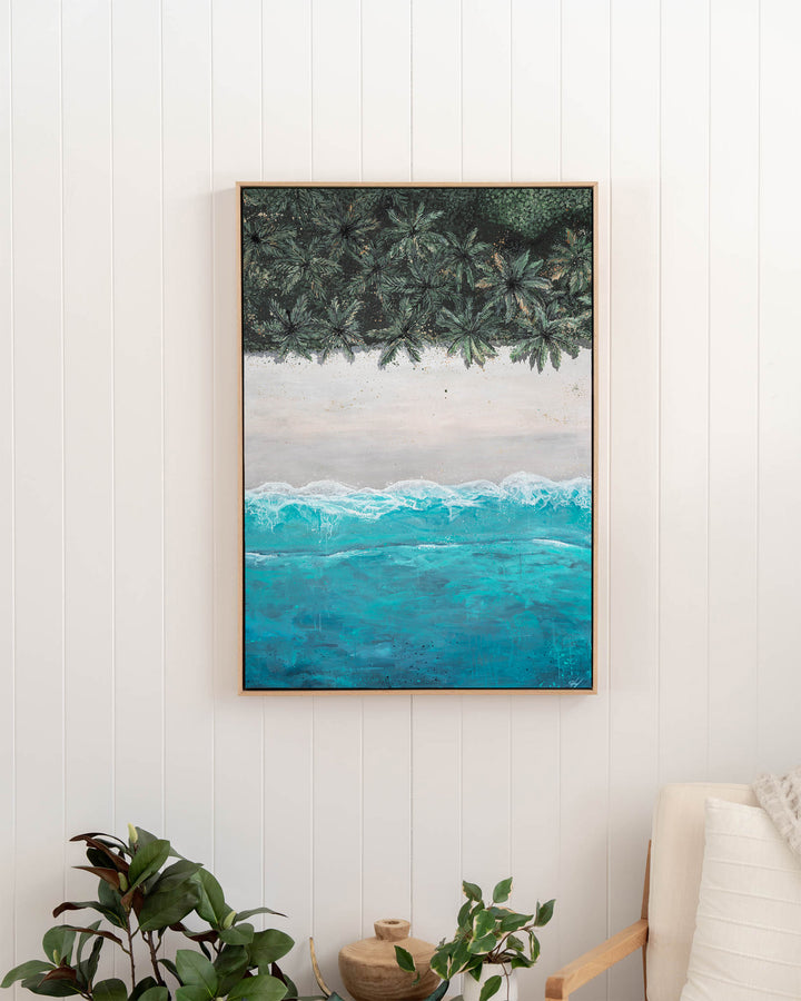 The Path Between – aerial beach and palm landscape, framed canvas in oak float frame, styled in a hallway