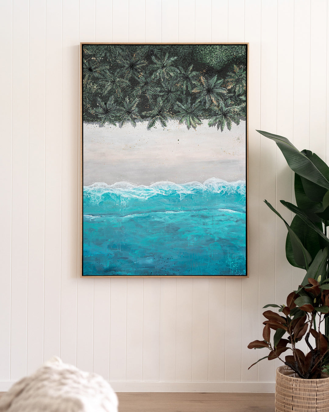 The Path Between – aerial beach and palm landscape, framed canvas in oak float frame, styled in a living room