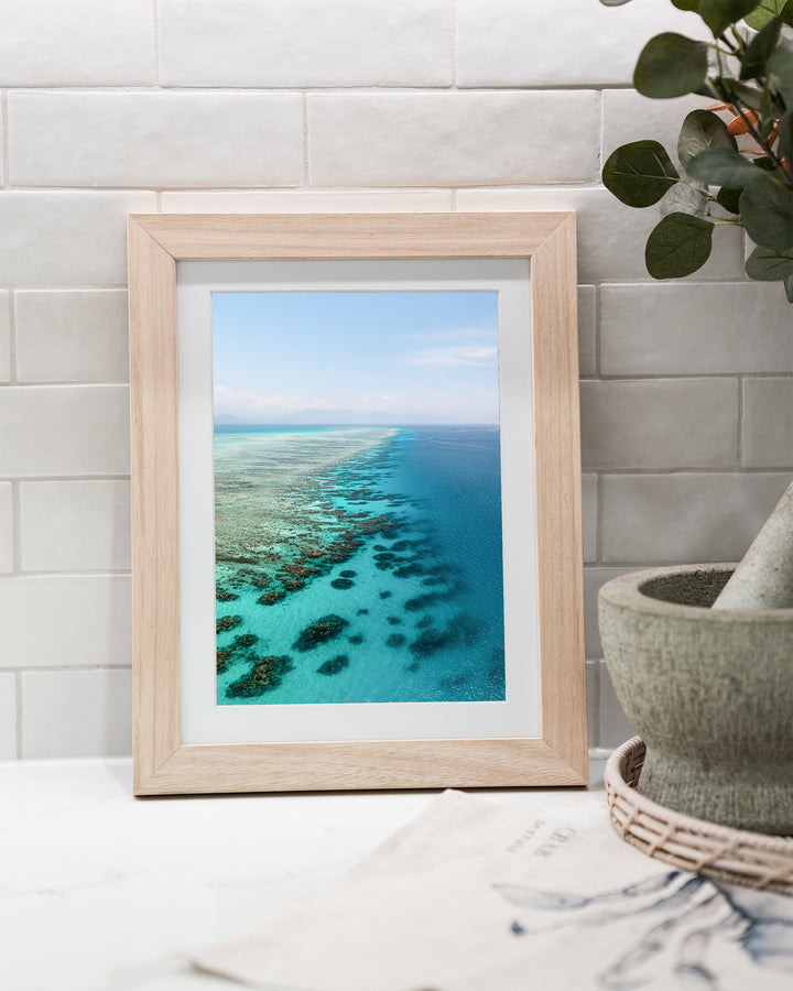 Tip of the Tongue – Tongue Reef, Aerial Photography by David Lloyd, framed paper print in oak frame, styled in a kitchen bench setting