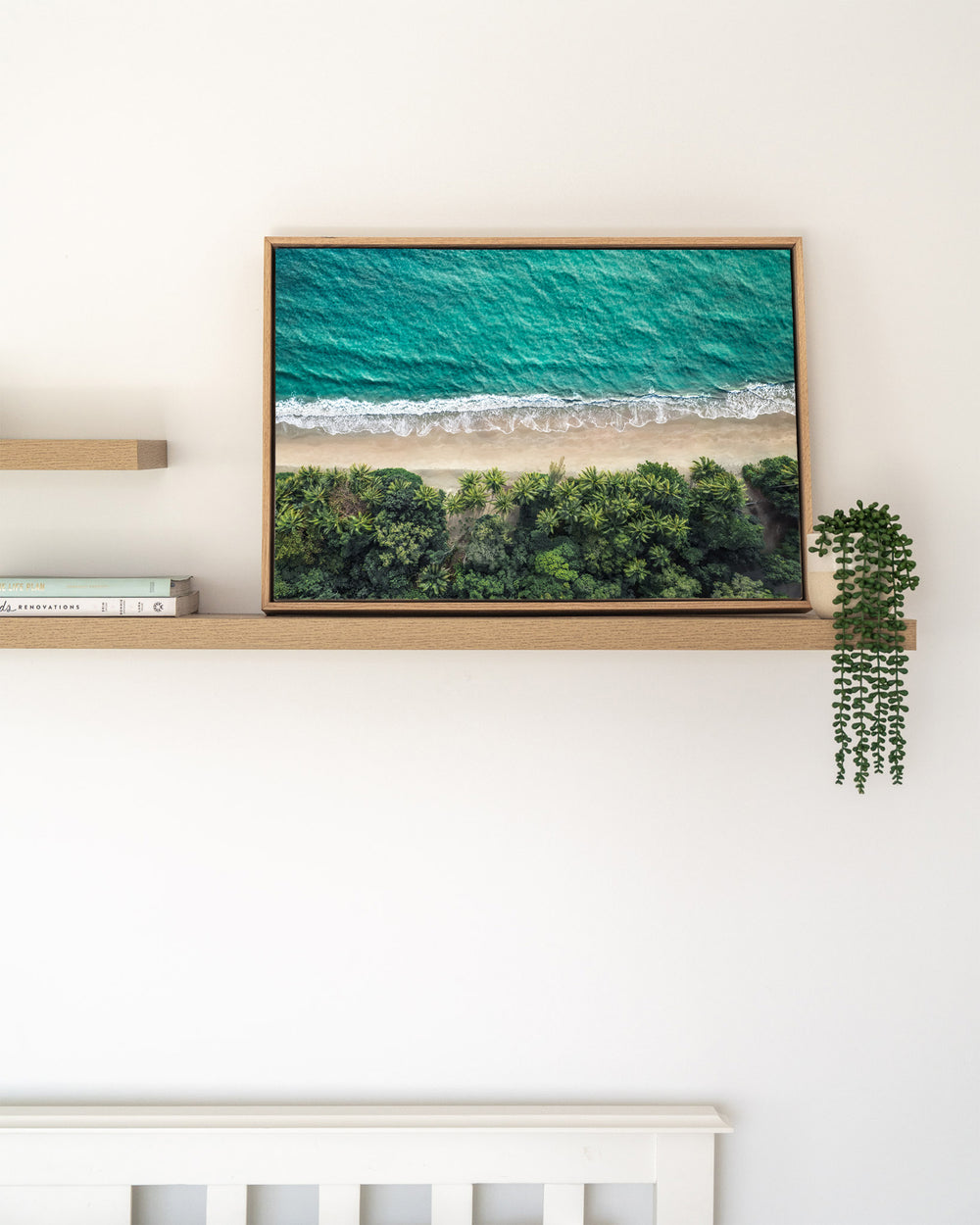 Tropical Tapestry – Four Mile Beach, Port Douglas, Aerial Photography by David Lloyd, framed canvas print in oak float frame, styled in a timber shelf setting