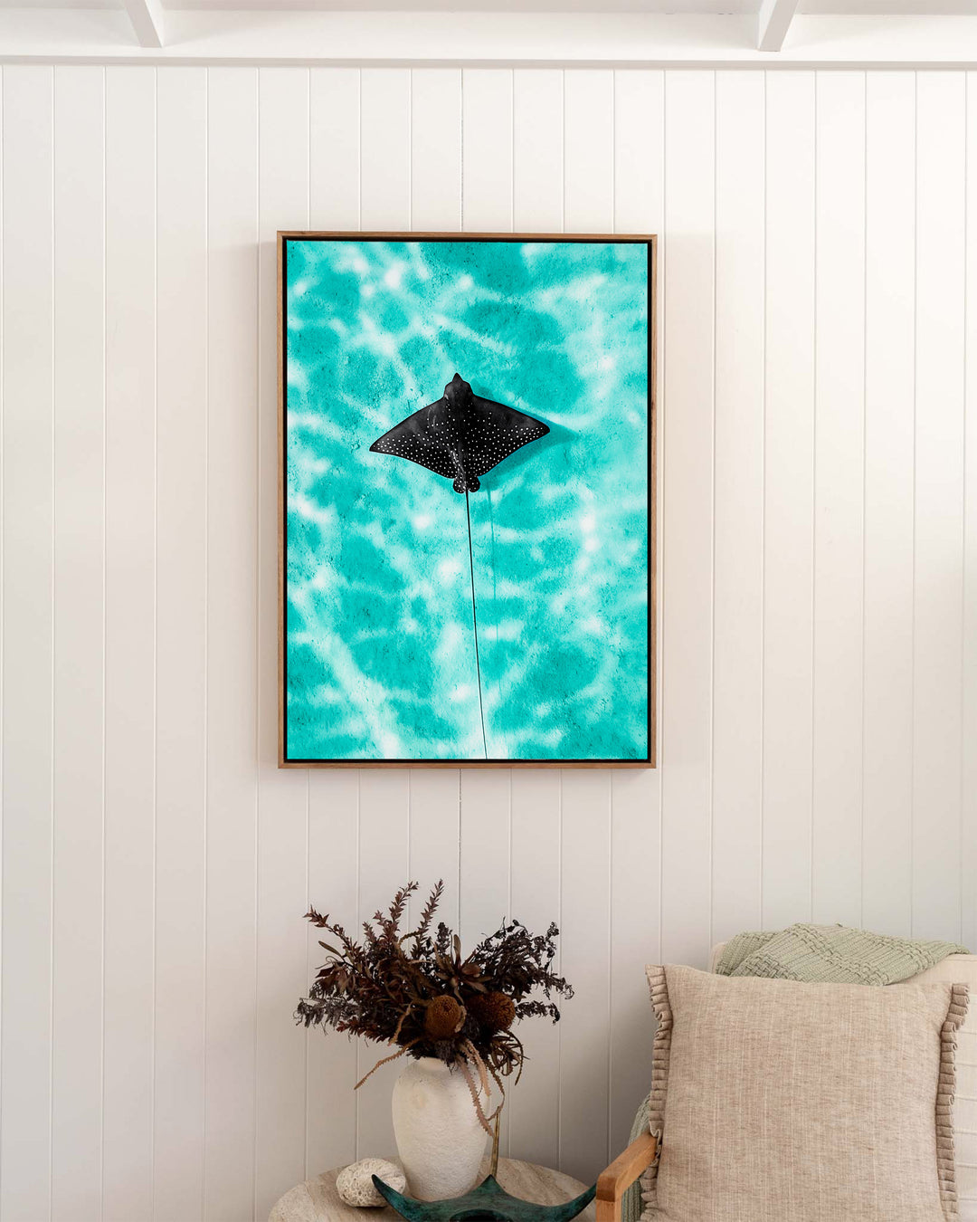 Turquoise Tranquility – Eagle Ray, Underwater Photography by David Lloyd, framed canvas print in oak float frame, styled in a bedroom setting