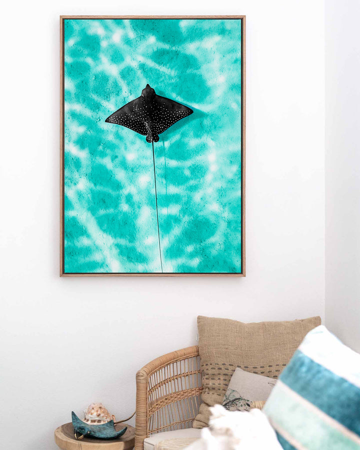Turquoise Tranquility – Eagle Ray, Underwater Photography by David Lloyd, framed canvas print in oak float frame, styled in a coastal lounge setting