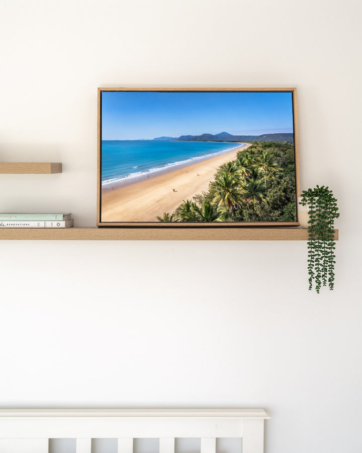 Walking the Miles – Four Mile Beach, Port Douglas, Aerial Photography by David Lloyd, framed canvas print in oak float frame, styled in a timber shelf setting