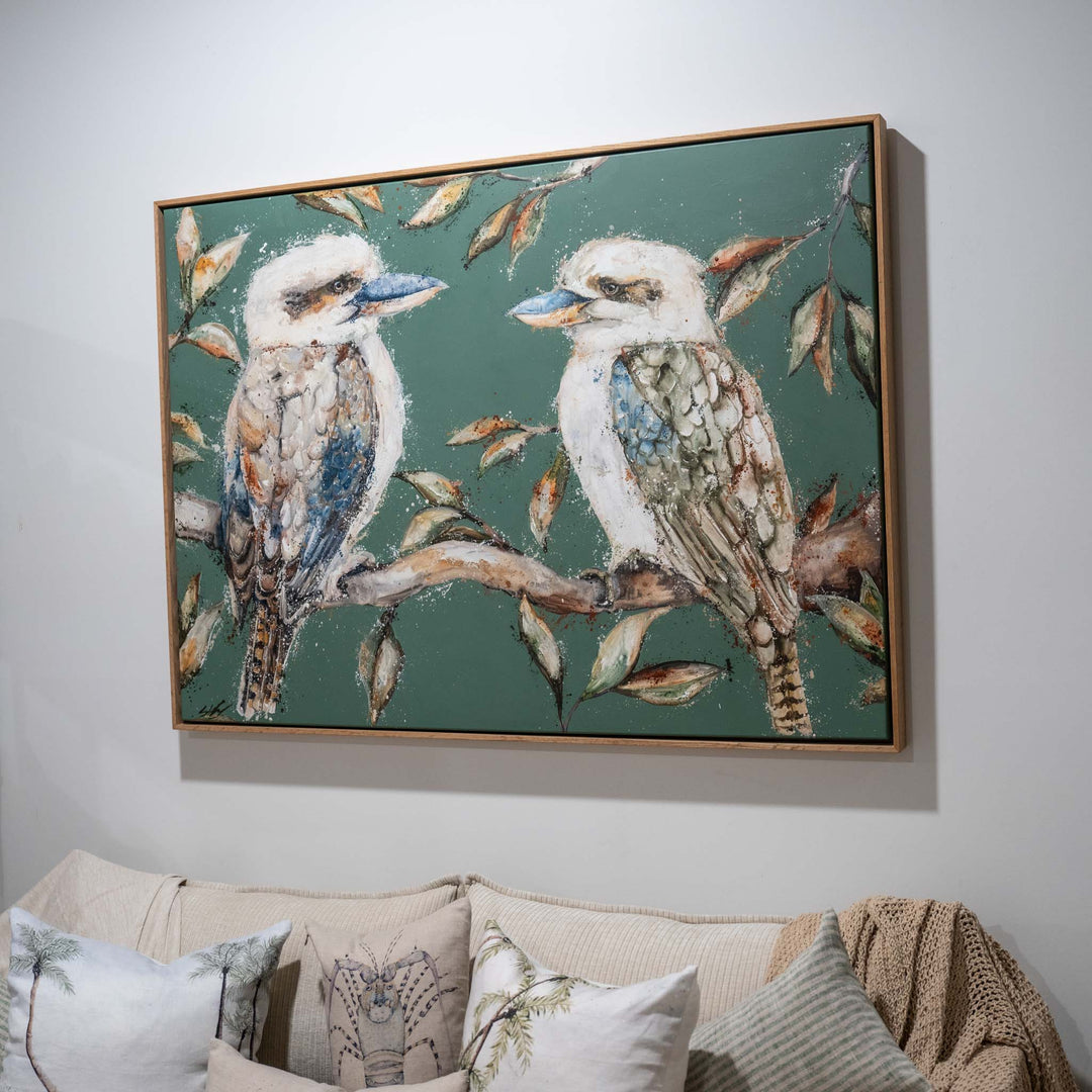 We Belong Together artwork hangs above a beige sofa, showing two kookaburras perched on a branch.