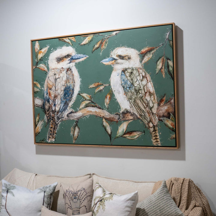 We Belong Together artwork hangs above a beige sofa, showing two kookaburras perched on a branch.