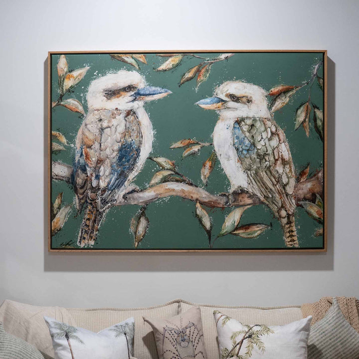 We Belong Together“ kookaburras art print hung above a comfortable couch in a home setting.
