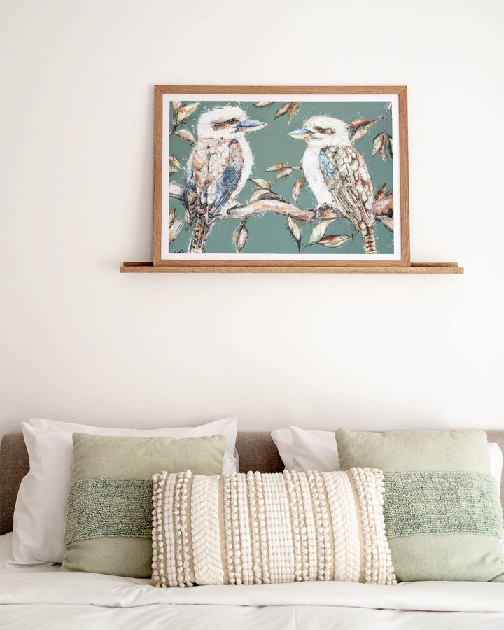 We Belong Together – kookaburras, framed paper print in oak frame, styled above a bed