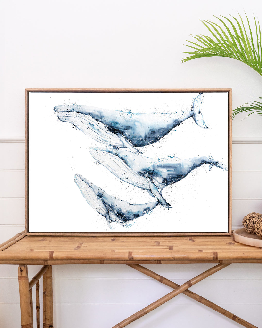 When We Go, We Go Together – humpback whales, framed canvas in oak float frame, styled on a rattan table