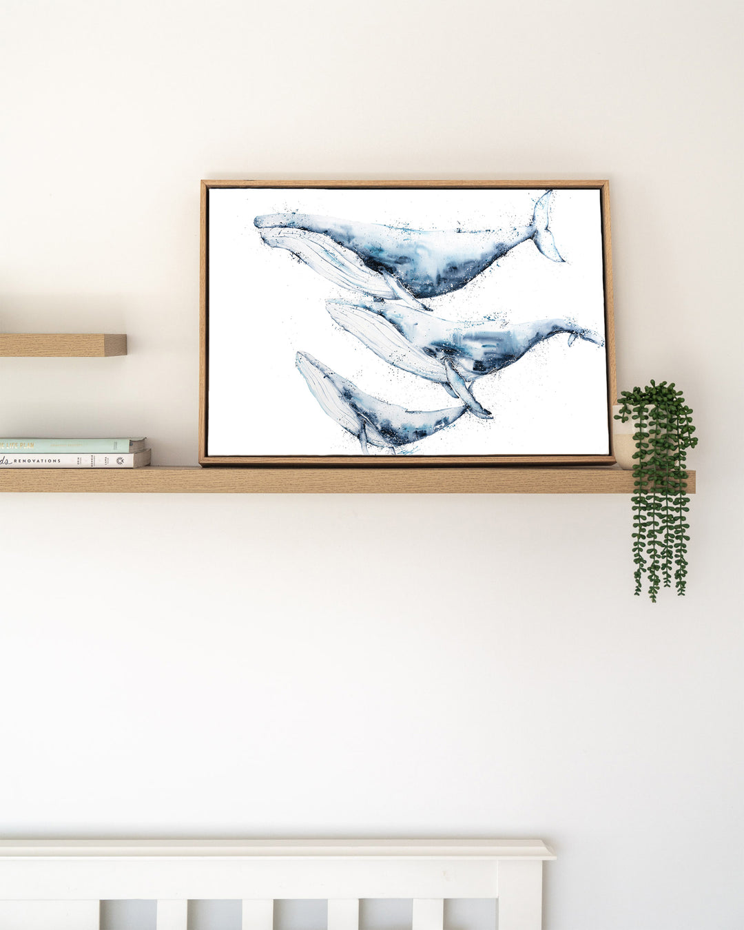When We Go, We Go Together – humpback whales, framed canvas in oak float frame, styled on a floating shelf