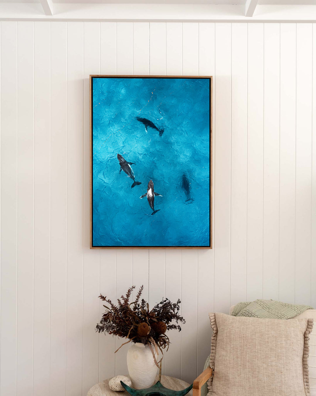 Whirlpool – Humpback Whales, Aerial Photography by David Lloyd, framed canvas print in oak float frame, styled in a bedroom setting