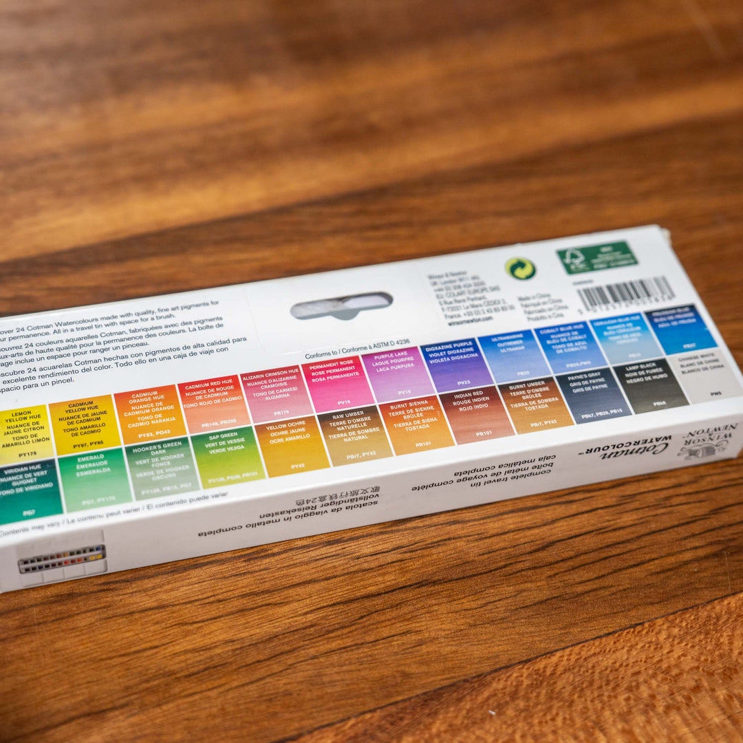 SEA Gallery Windsor &amp; Newton 24 Piece Watercolour Set with labeled colors arranged on a wooden tabletop.