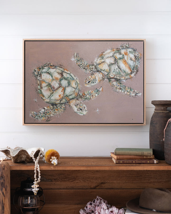Winter Solstice – green sea turtles, framed canvas in oak float frame, styled above a timber console